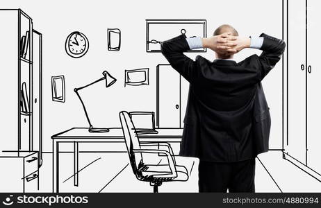 Office worker. Young confident businessman standing in drawn office