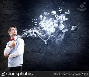 Office worker. Young handsome businessman in fumes smoking pipe