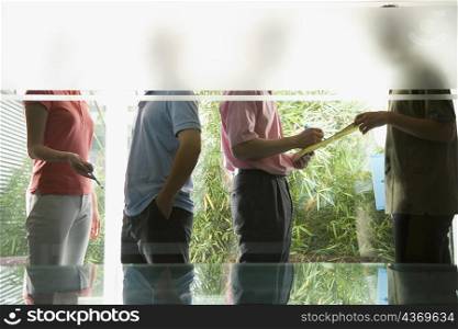 Office workers discussing to each other viewed through a glass