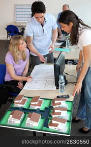 Office workers looking at architect plans