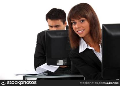 Office workers sitting at desktop computers