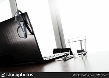 Office workplace with laptop and smart phone and eye glasses on wood table