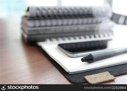 Office workplace with laptop and smart phone and stylus on wood table