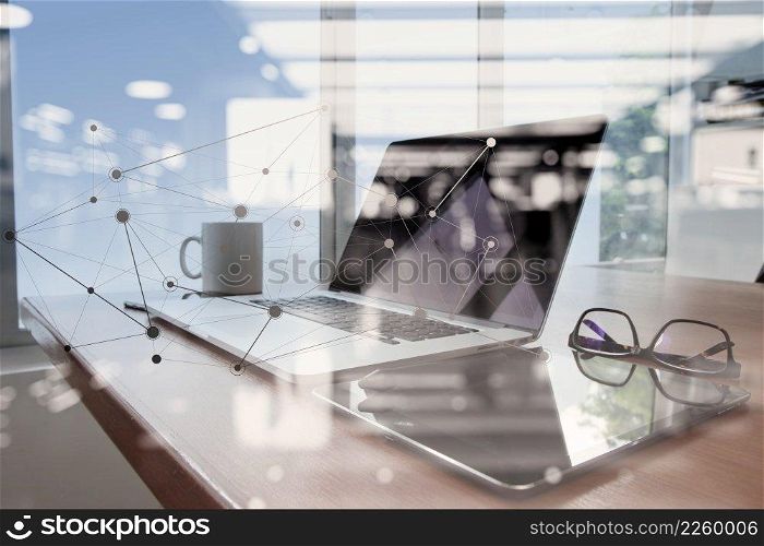 Office workplace with laptop and smart phone on wood table with eyeglasses on digital tablet