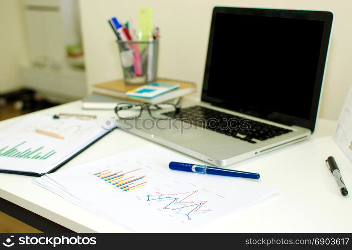 Office workplace with laptop on desk.