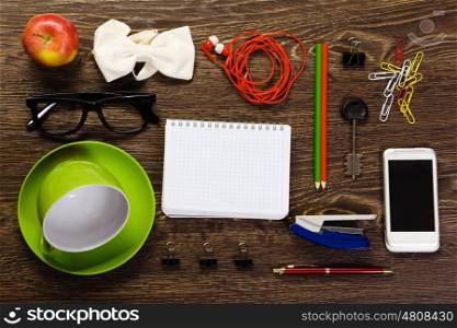 Office workplace with notepad, cup, mobile phone and stationary