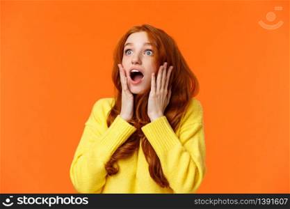 Oh no something falling from sky. Shocked and speechless, startled young concerned redhead woman drop jaw, gasping and staring upper left corner concerned, touching face worried, orange background.. Oh no something falling from sky. Shocked and speechless, startled young concerned redhead woman drop jaw, gasping and staring upper left corner concerned, touching face worried, orange background
