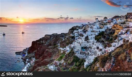 Oia town on Santorini island, Greece at sunset. Traditional and famous windmills on cliff over the Caldera, Aegean sea. High res panorama