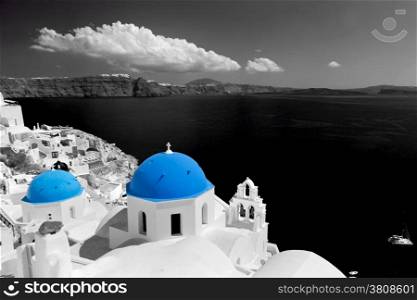 Oia town on Santorini island, Greece. Black and white styled with blue dome of traditional church over the Caldera, Aegean sea