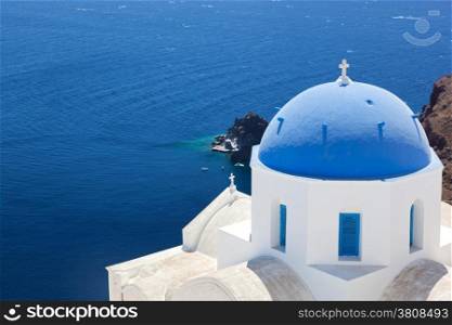 Oia town on Santorini island, Greece. Traditional and famous church with blue dome over the Caldera, Aegean sea