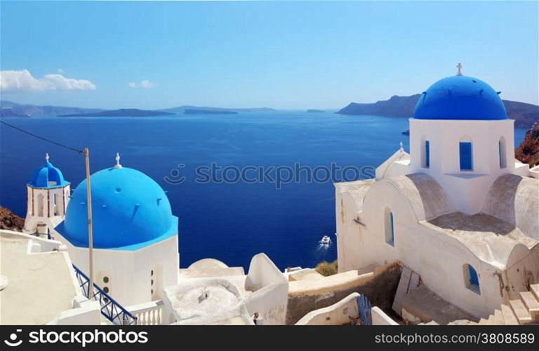 Oia town on Santorini island, Greece. Traditional and famous houses and churches with blue domes over the Caldera, Aegean sea. Panorama