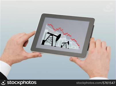 oil business, energy crisis, people and technology concept - close up of man hands holding tablet pc computer with pump jacks and graph on screen over gray background