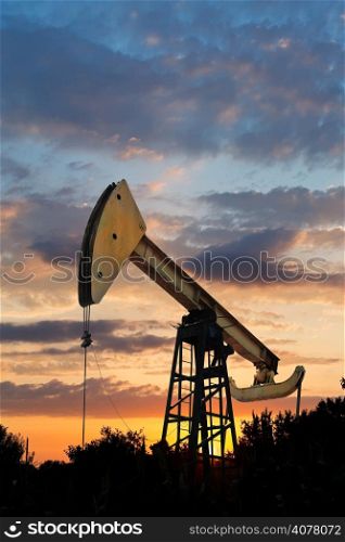oil extraction by pumpjack in Caucasus region at summer sunset