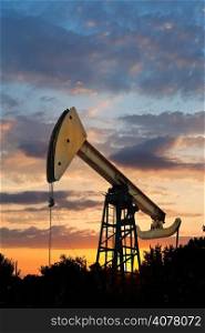 oil extraction by pumpjack in Caucasus region at summer sunset