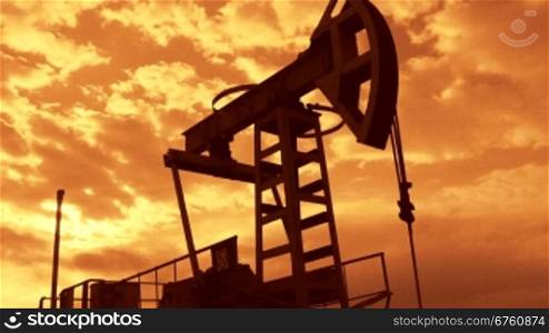 Oil industry equipment pump jack in motion at sunset