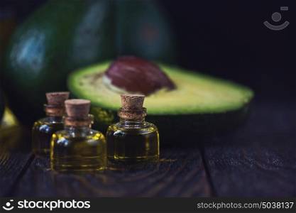 Oil of avocado. Oil of avocado on a dark wooden background