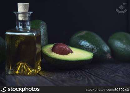 Oil of avocado. Oil of avocado on a dark wooden background