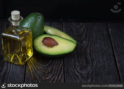 Oil of avocado. Oil of avocado on a dark wooden background