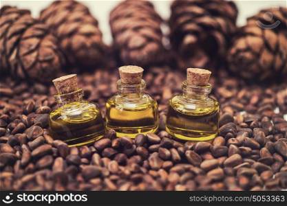 Oil of cedar nuts. The cedar oil in a glass bottles on the cedar nuts