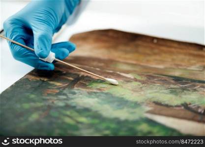 Oil painting cleaning, female conservator removing dirt from an old oil painting. Oil Painting Cleaning