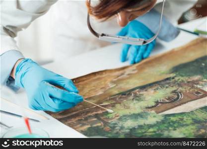 Oil painting cleaning, female conservator removing dirt from an old oil painting. Oil Painting Cleaning