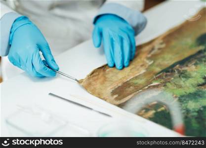 Oil painting restoration expert repairing damage on the canvas. Oil Painting Restoration