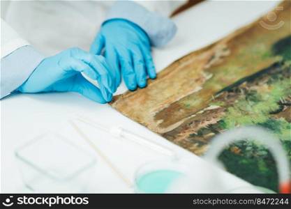 Oil painting restoration expert repairing damage on the canvas. Oil Painting Restoration