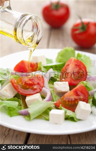 oil pouring over fresh salad