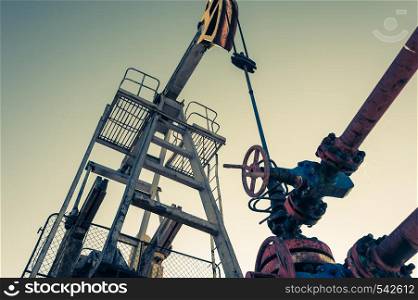 Oil pump, industrial equipment on sunset sky background. Rocking machines for extraction of oil. Mining. Petroleum concept.. Oil pump, industrial equipment. Rocking machines for extraction of oil. Mining. Petroleum concept.
