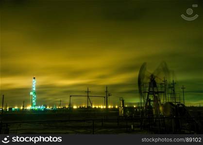 Oil pump jack and drilling rig at the night sky background. Long exposure.