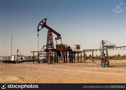 Oil pump jack and wellheads. Extraction of oil.