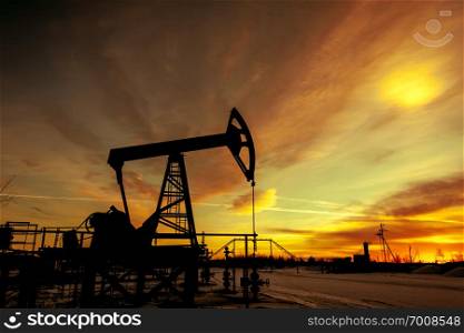 Oil pump jack on a oil field. Sunset sky background. Extraction of oil. Petroleum concept. Toned.. Pump jack. Extraction of oil. Petroleum concept.