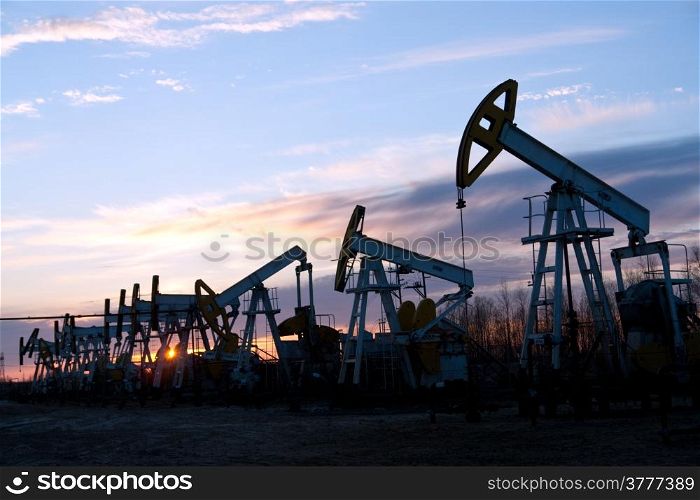 oil pumps at sunset sky background