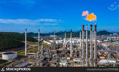 Oil? refinery? and? petrochemical? plant industrial working with fire and blue sky background, Aerial view oil and gas refinery at day.