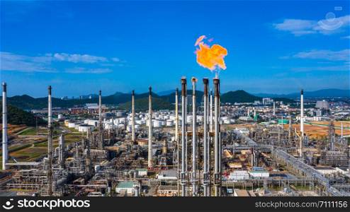 Oil? refinery? and? petrochemical? plant industrial working with fire and blue sky background, Aerial view oil and gas refinery at day.