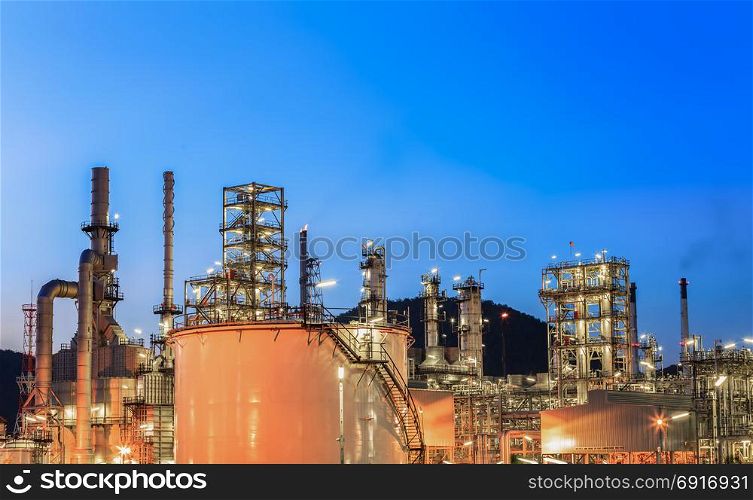 Oil refinery plant and storage tank with sunset