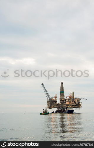 Oil rig being tugged in the sea