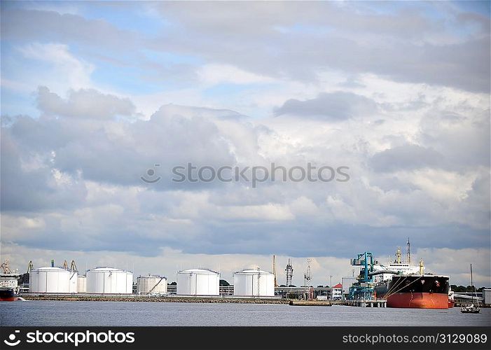 Oil Storage tanks at harbor under cloudy sky