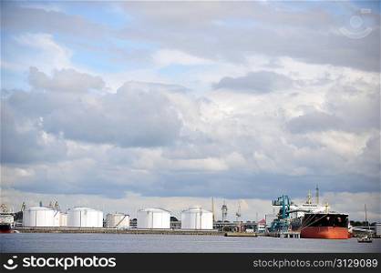 Oil Storage tanks at harbor under cloudy sky