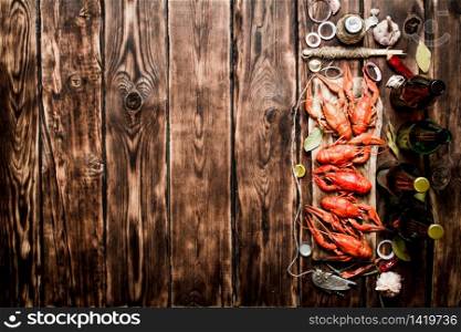 oiled crawfish with beer bottles on the old Board. On Wooden background.. oiled crawfish with beer bottles on the old Board.