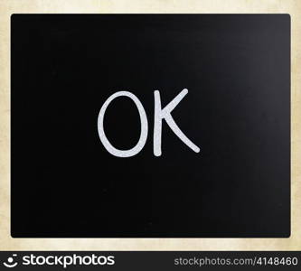 ""OK" handwritten with white chalk on a blackboard"