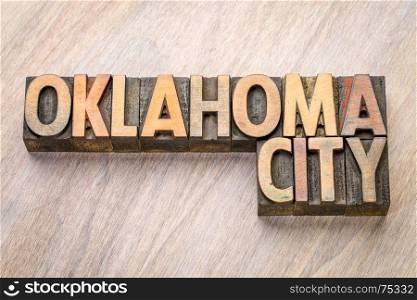 Oklahoma City word abstract in vintage letterpress wood type against grained wooden background