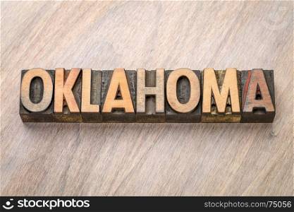 Oklahoma word abstract in vintage letterpress wood type against grained wooden background