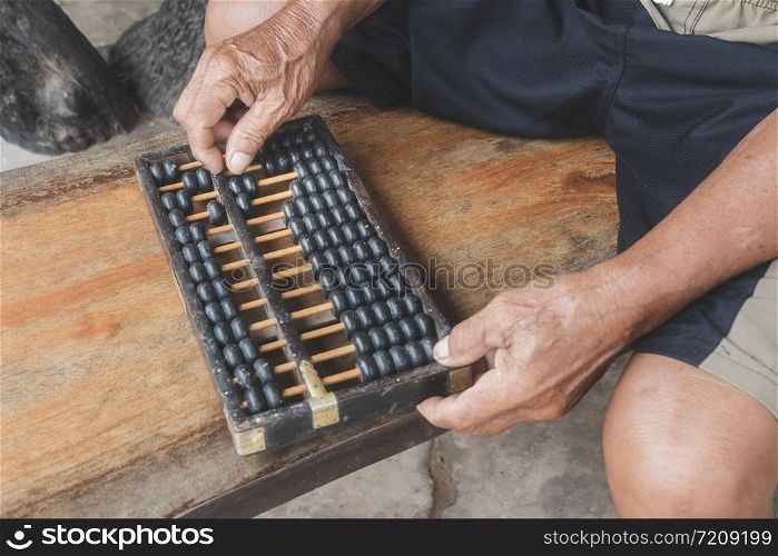 old abacus and hand on wooden background