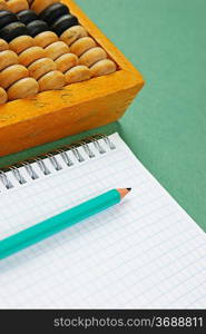 old abacus and notebook on the green background