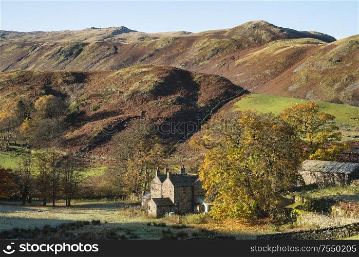 Old abandoned farm buildings in Autumn Fall landscape image in Lake District with Sleet Fell in background with epic light on the fells