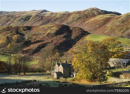 Old abandoned farm buildings in Autumn Fall landscape image in Lake District with Sleet Fell in background with epic light on the fells