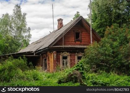 Old abandoned grassy log wooden house in russian village, Vladimir region. Summer day