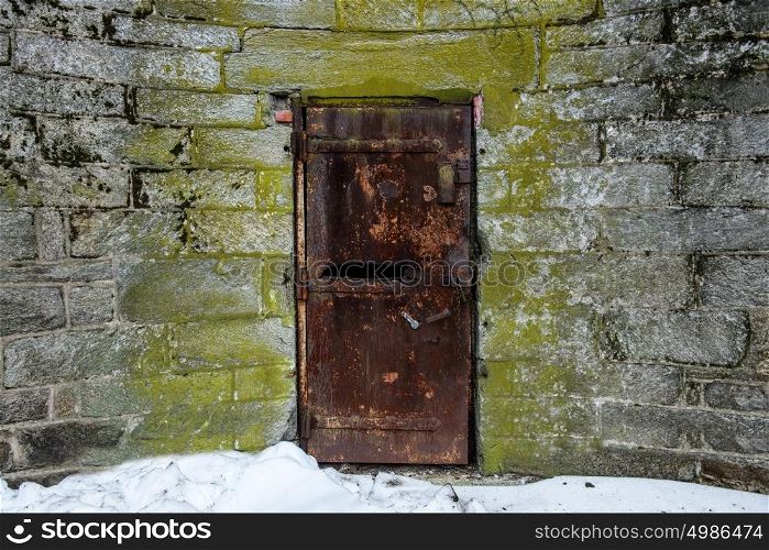 Old abandoned metal door with rust in castle wall