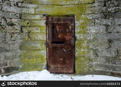 Old abandoned metal door with rust in castle wall